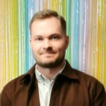 Miesolettu henkilö, jolla on vaalearuskeat lyhyet hiukset ja vaaleat piirteet. Samulilla on tumma lyhyt parta. Päällään Samulilla on vaalea kauluspaita ja ruskea kauluspaita sen päällä.